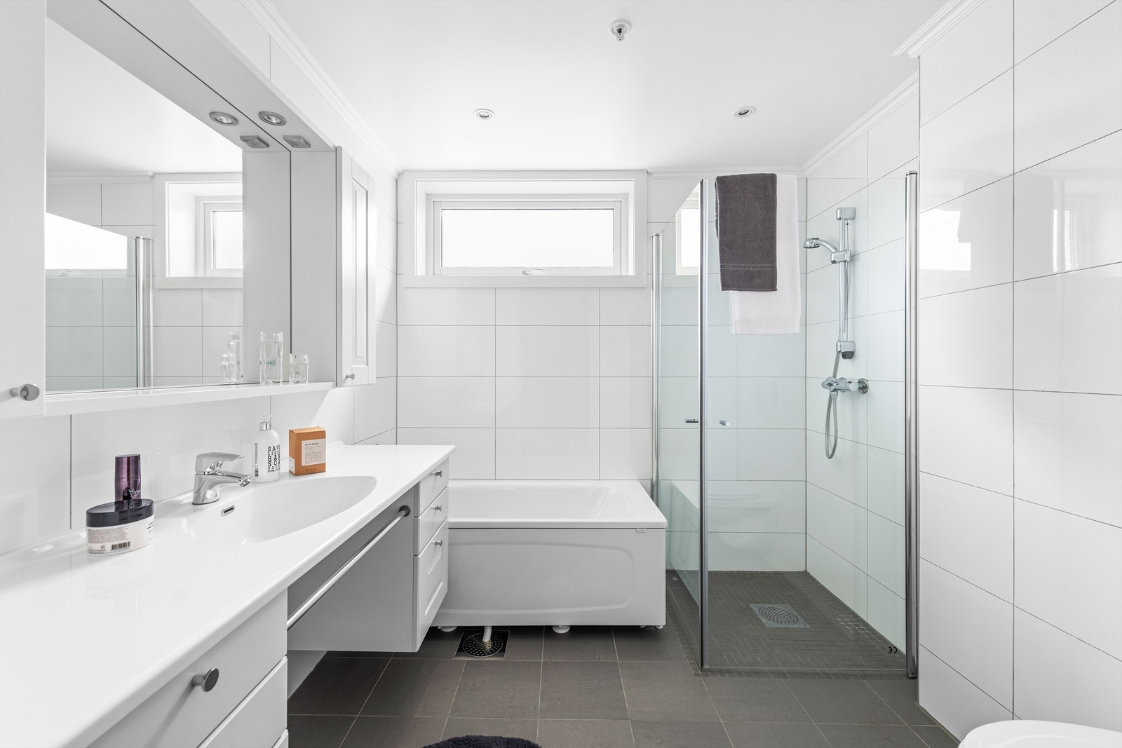 Delikat flislagt bad med både badekar og dusjhjørne Galleribilde