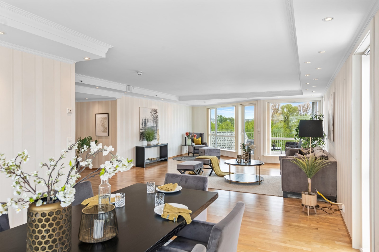 Lys og innbydende stue med gjennomgående naturlig lys fra store vindusflater Galleribilde