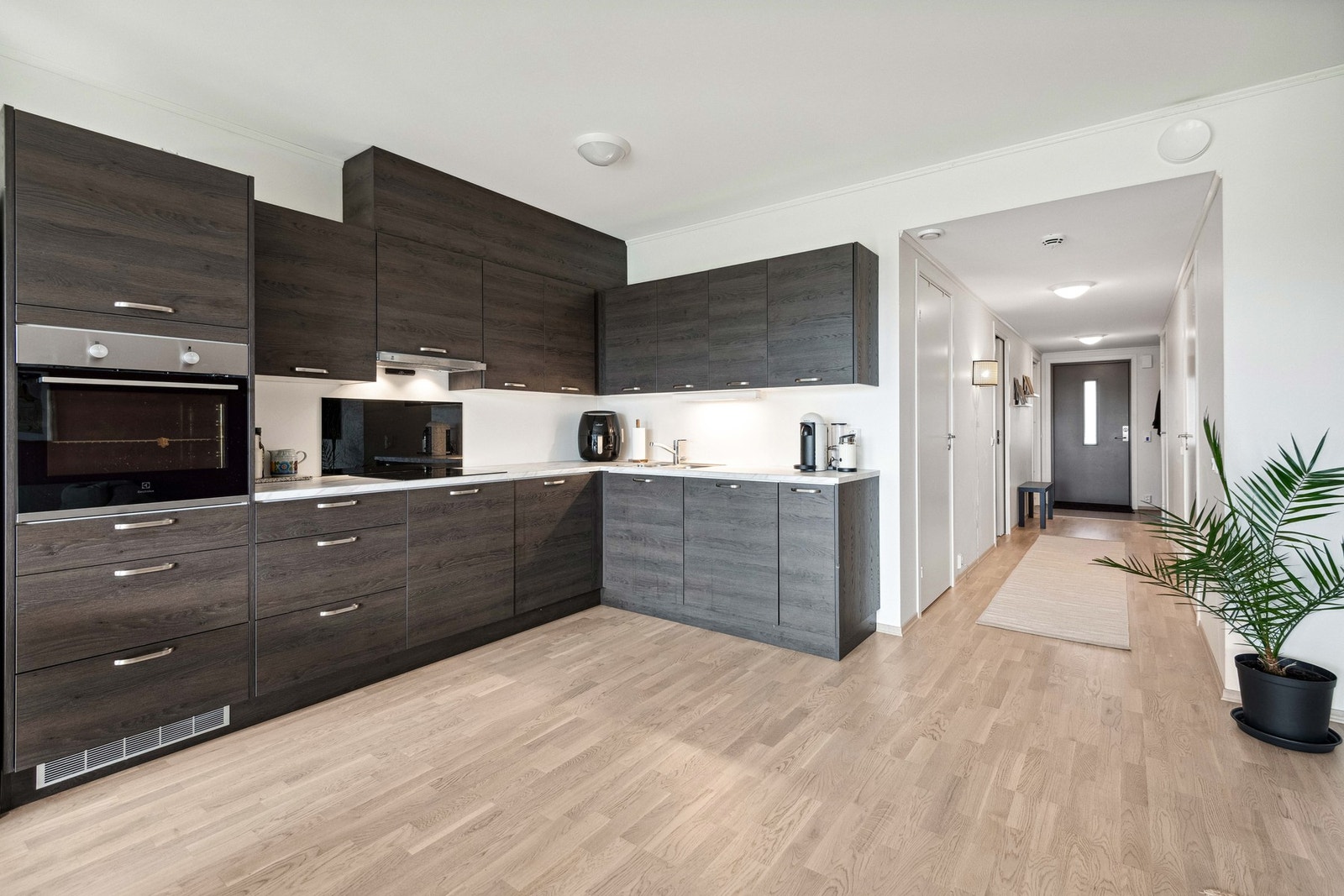 Romslig kjøkkenløsning med delvis integrerte hvitevarer. Galleribilde