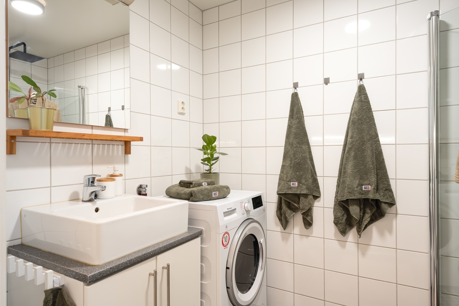 Delikat, flislagt bad med varmekabler i gulv. Fin kombinasjon mellom mosaikkflis på gulv og større, hvite fliser på vegger. Galleribilde