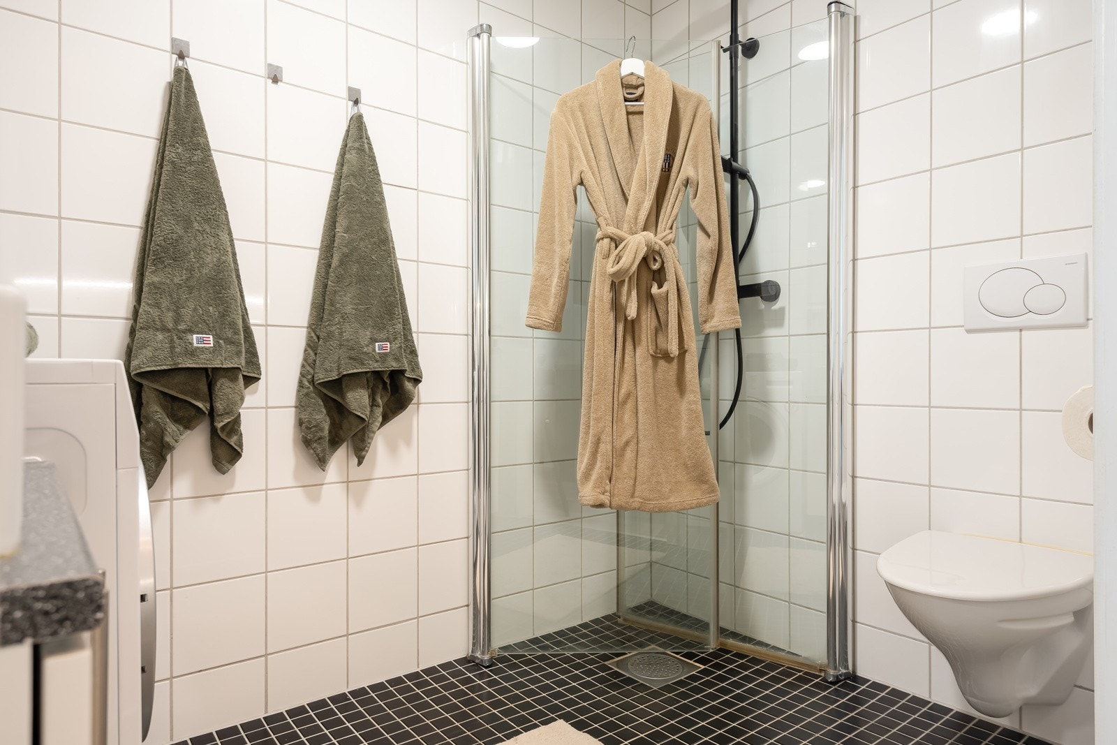 Rommet er utstyrt med vegghengt toalett, dusjhjørne m/innfellbare glassdører og opplegg for vaskemaskin. Galleribilde
