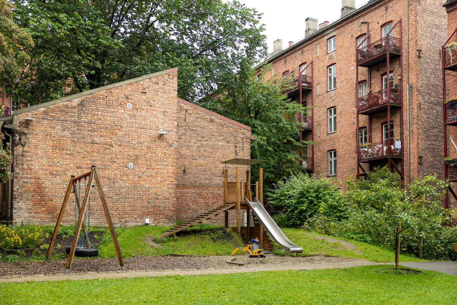 Lekeplass fra 2019 i bakgården med sklie, huske, og sandkasse. Galleribilde