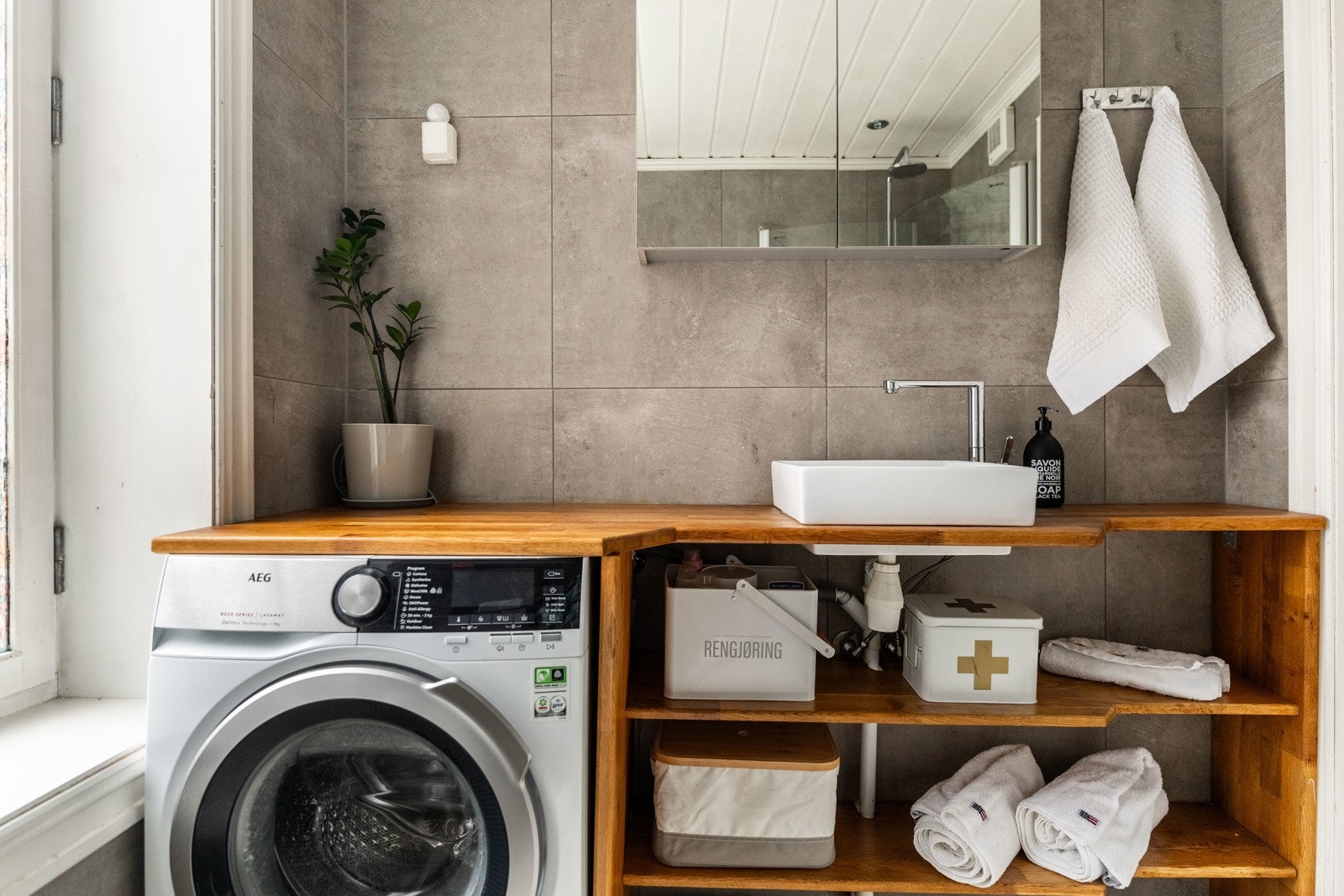 Badet har opplegg for vaskemaskin og avtrekksventil på vegg. Galleribilde