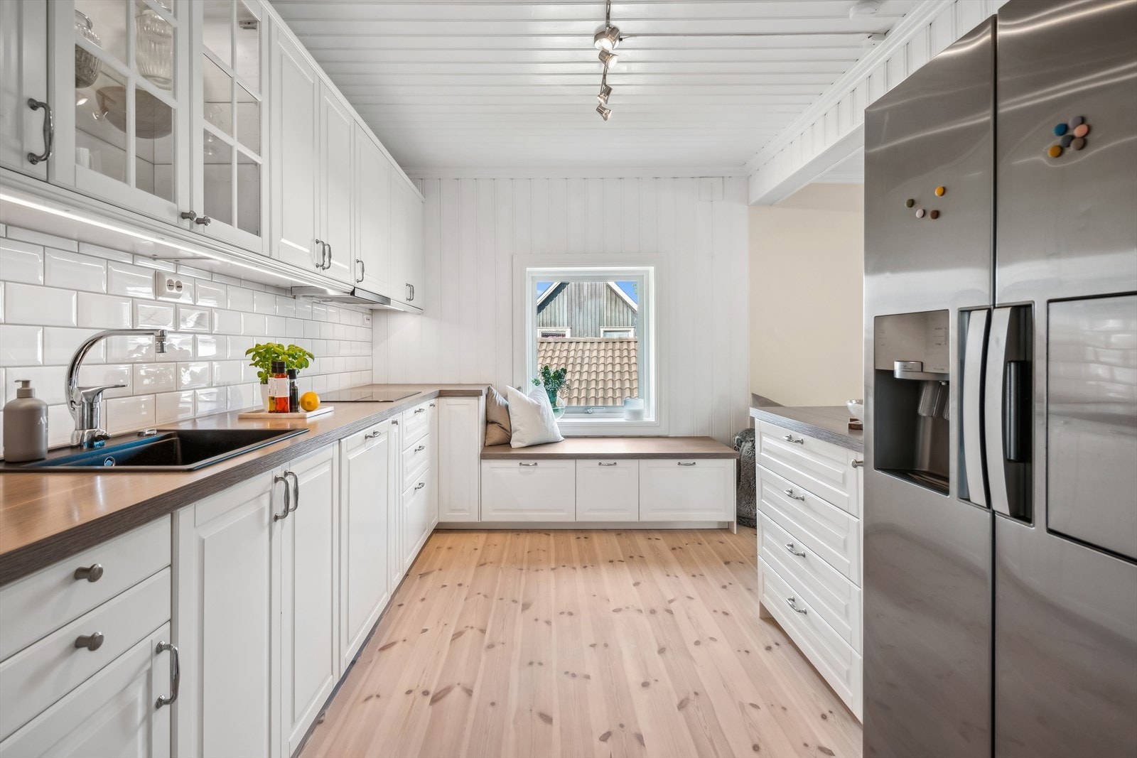 Det er benkeplaten av laminat og fliser mellom over og underskap. Det er også komfyrvakt og vannstoppsystem. Galleribilde