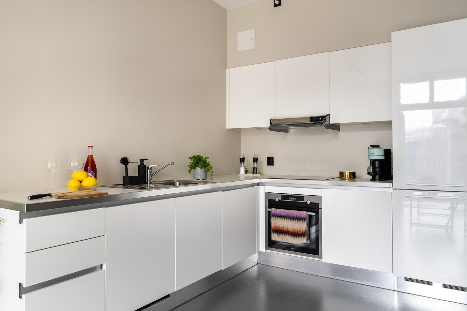 Kjøkkenet har integrerte hvitevarer og kjøkkenvifte plassert i overskap tilknyttet avtrekkskanal. Galleribilde