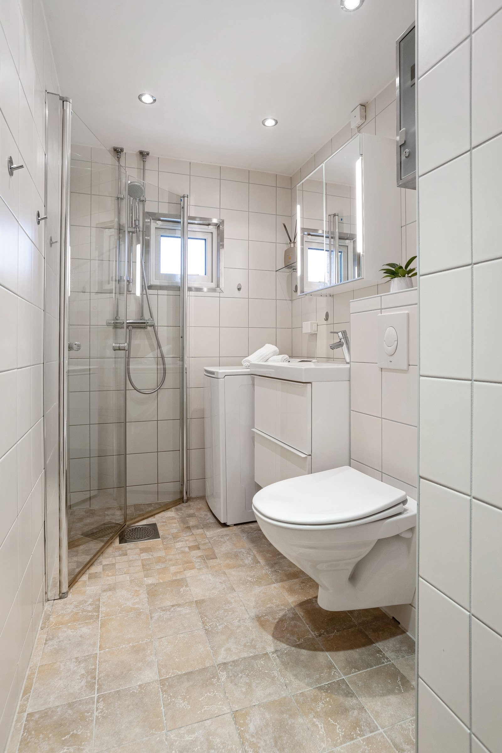 Pent, flislagt baderom med gulvvarme og downlights, samt vegg montert klosett og opplegg for vaskemaskin. Galleribilde