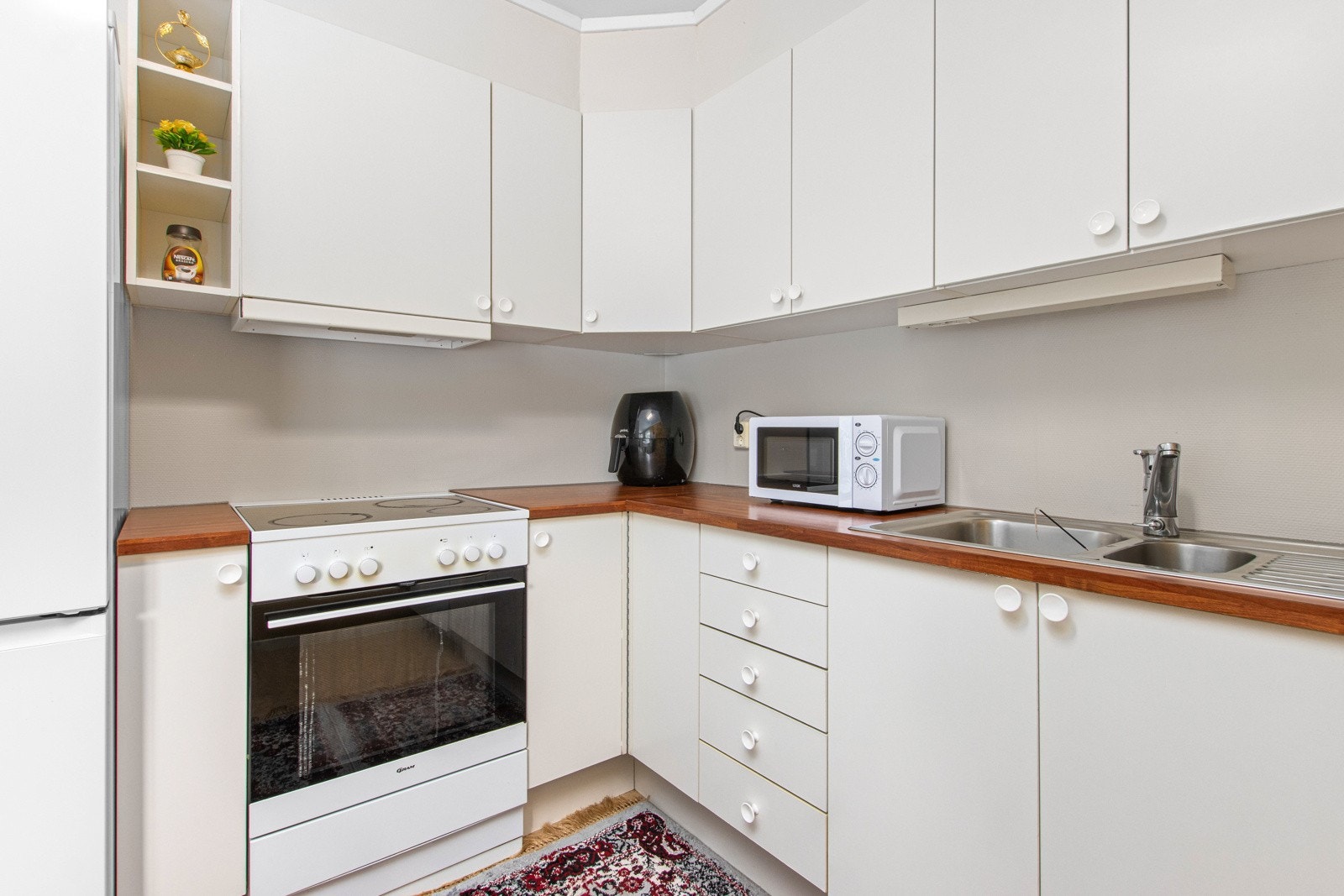 Kjøkken med opplegg for hvitevarer som komfyr, oppvaskmaskin og kjøle/fryseskap. Galleribilde