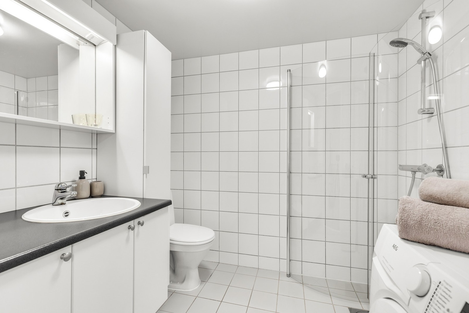 Badet er fra byggeår og er på 3,9 kvm. Pent flislagt med elektriske varmekabler Galleribilde