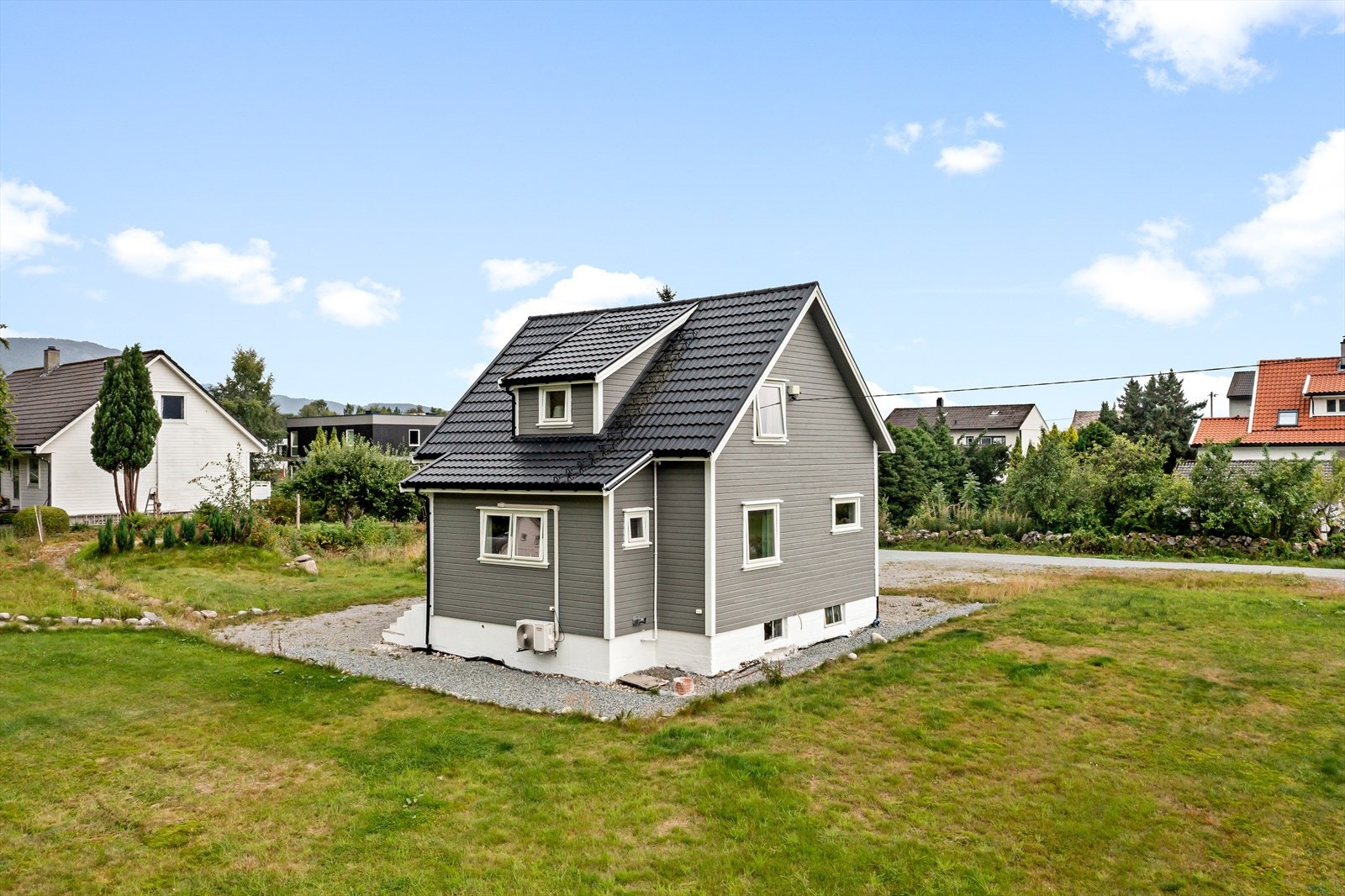 Meget romslig tomt på nesten 3 mål som er opparbeidet med grøntområder, diverse beplantninger, innkjørsel og en praktisk sti med grind ut til hovedveien. Galleribilde