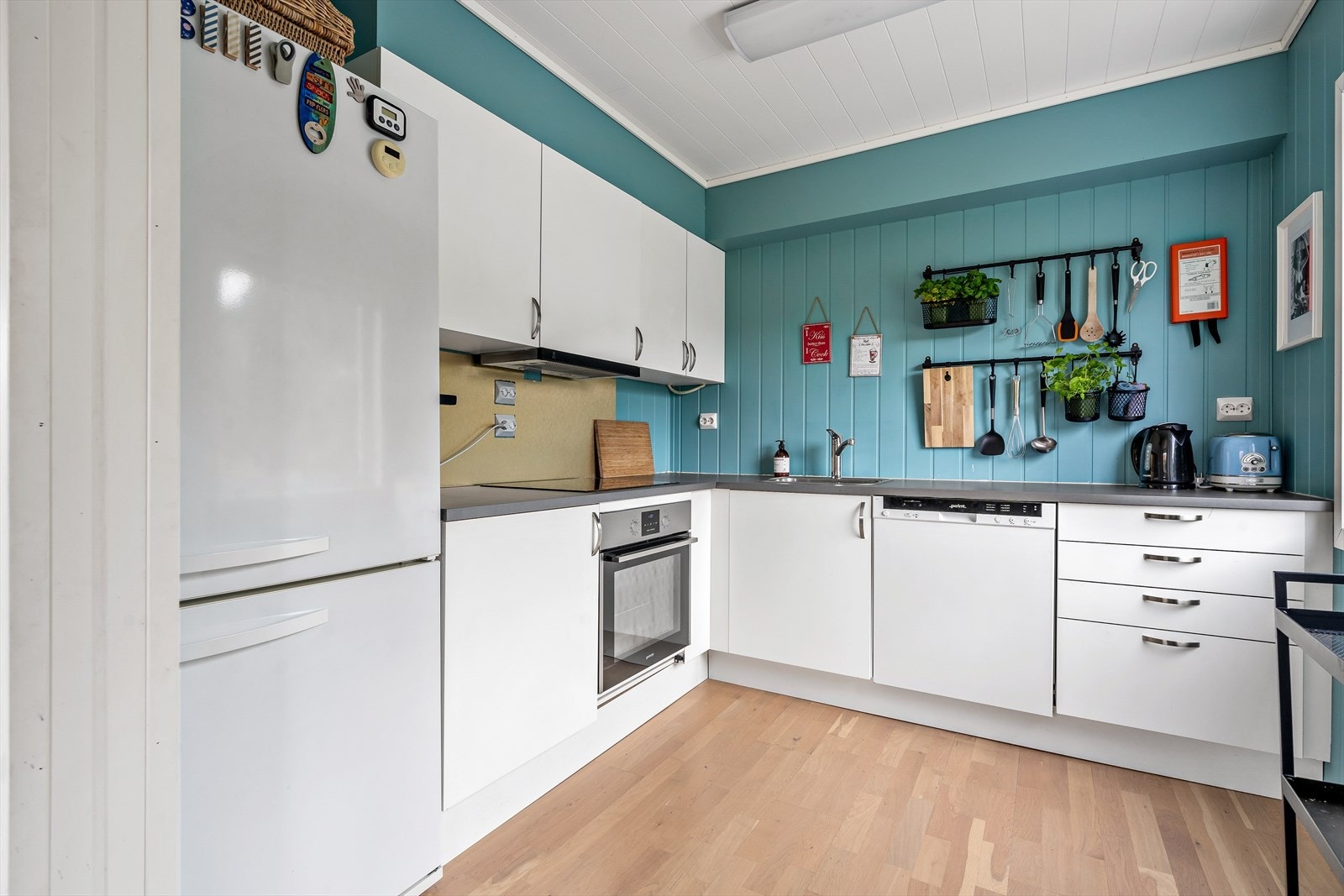 Velholdt kjøkkeninnredning med integrert komfyr og oppvaskmaskin. Galleribilde