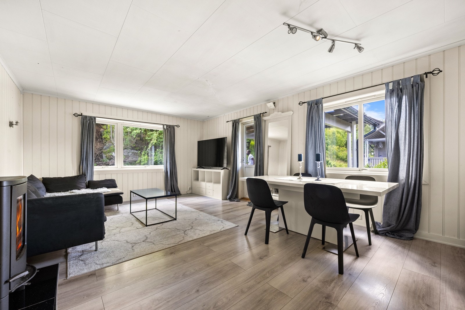 Den romslige stuen har god plass til både en komfortabel sofagruppe og et spisebord Galleribilde
