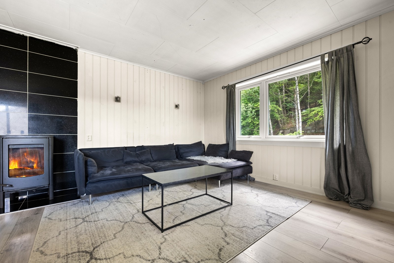 Stuen har en koselig peis som skaper en varm og innbydende atmosfære, perfekt for avslapning på kalde kvelder Galleribilde