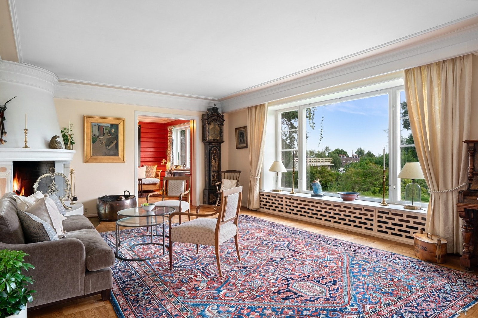 Stuen har peis og en flott utsikt mot hagen Galleribilde