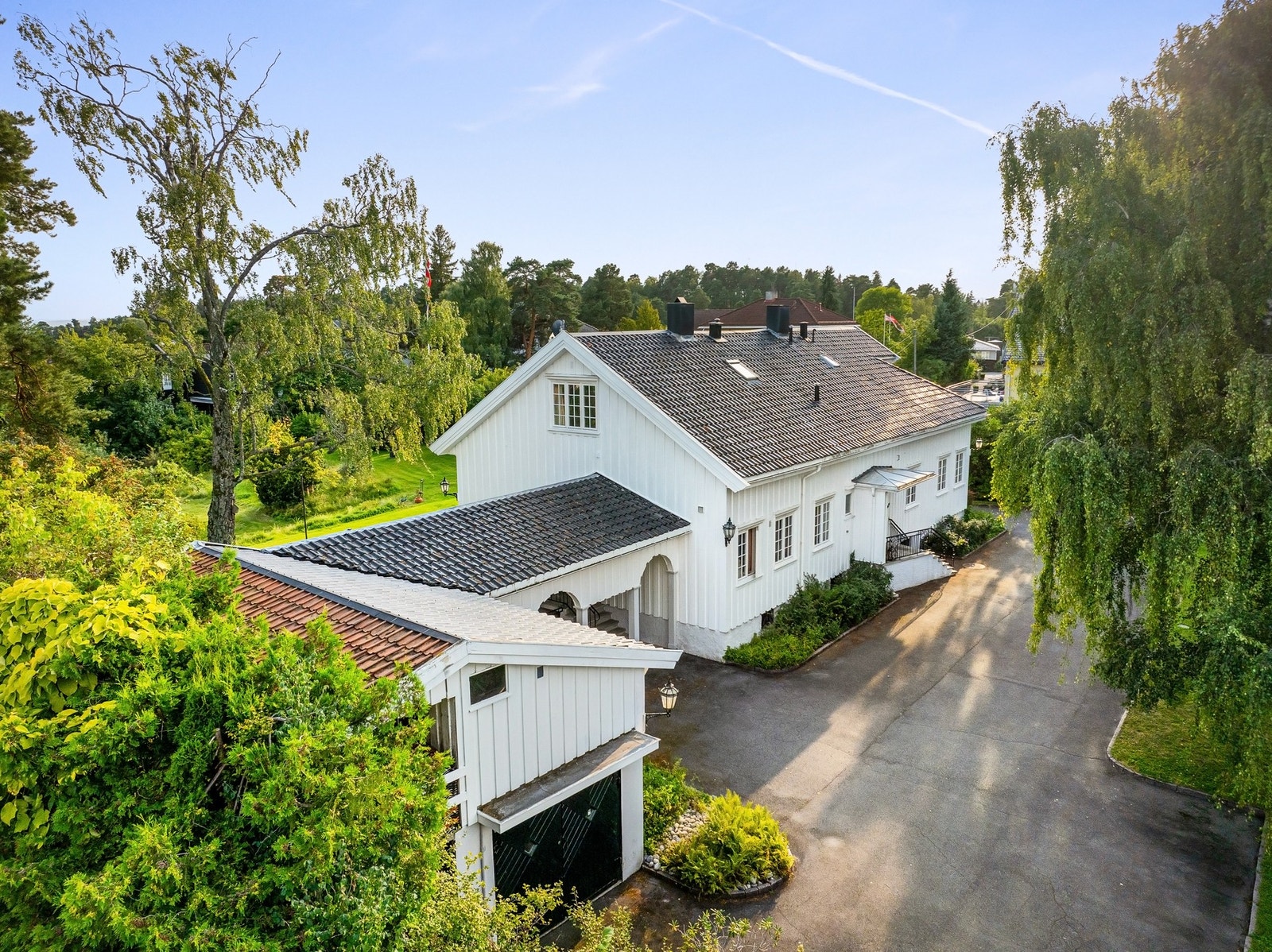 Vakker eiendom med mange kvaliteter. Her sett fra sidebygning med garasje over 2 etasjer. Galleribilde