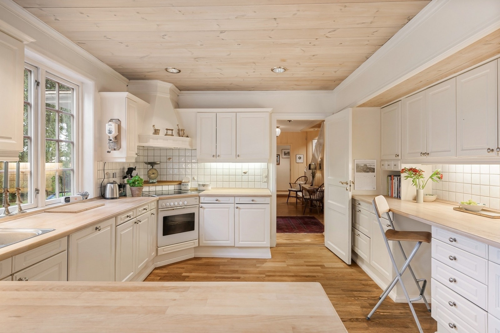 Kjøkken er delikat innredet med lyse fronter og benkeplate i lys bøk Galleribilde