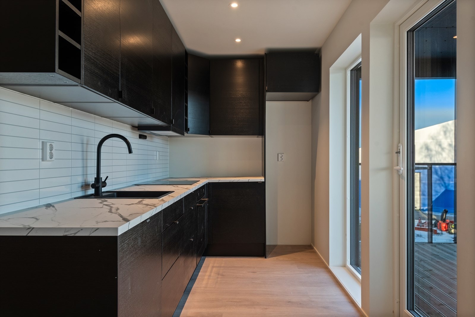 Kjøkkenet har integrerte hvitevarer og plass til kjøl-/fryseskap. Utgang til terrasse og plen Galleribilde