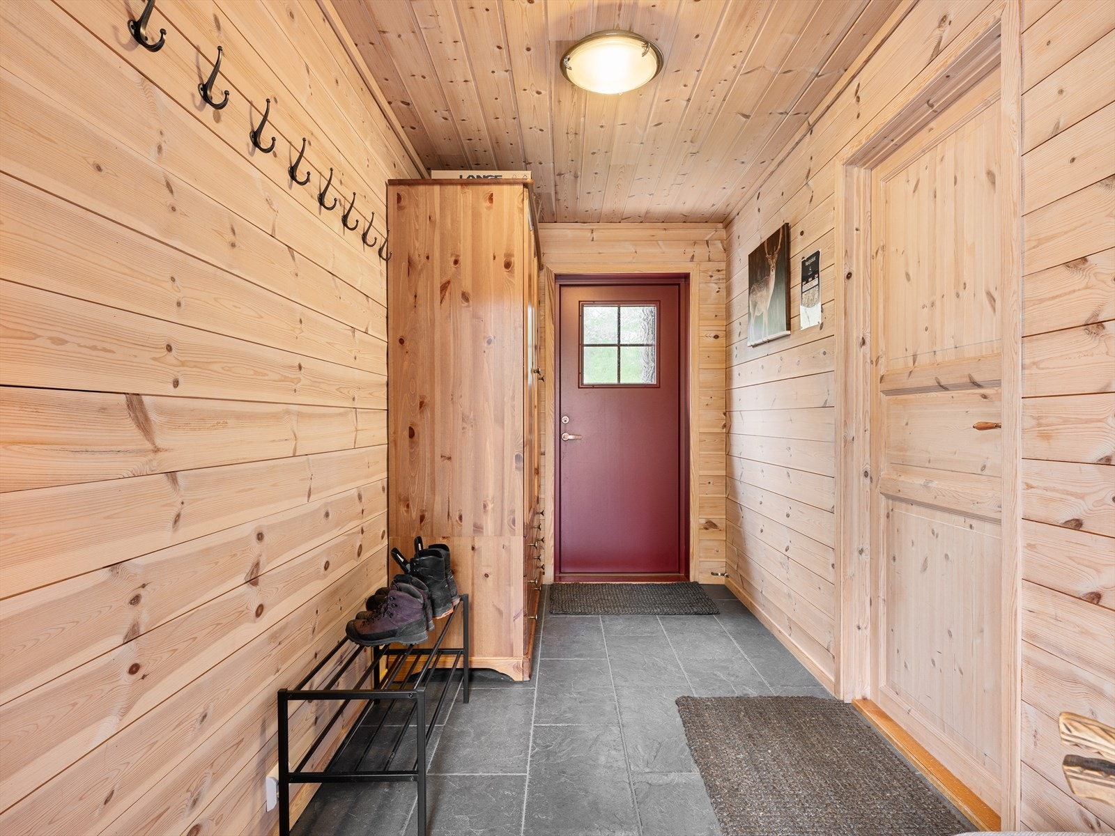 Entre med god plass for oppheng, skap/garderobe m.m. Varme i gulv og fliser for praktiske årsaker med våte skisko. Galleribilde