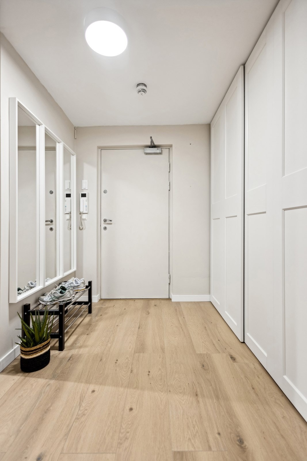 Man ønskes velkommen i en lys entré med skyvedørsgarderobe. Galleribilde
