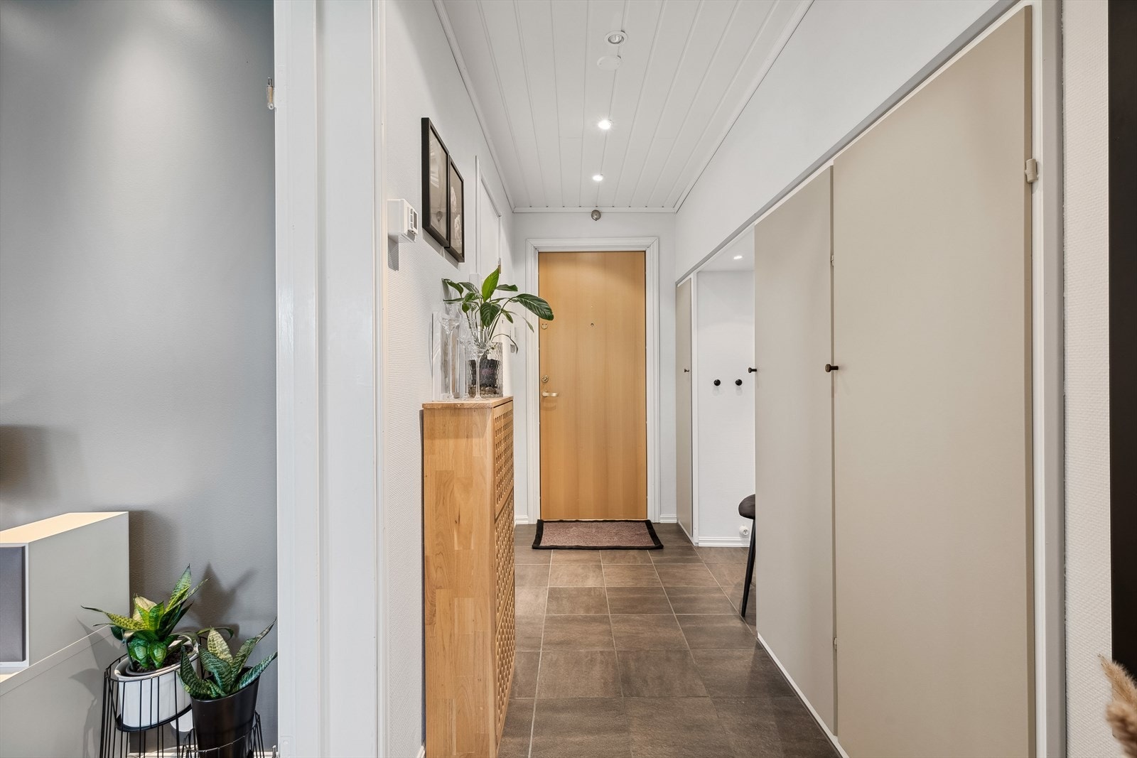 Velkommen inn til en lys og innbydende entré/gang med flislagte gulv m/varmekabler, og hvite overflater på vegger og i tak. Galleribilde