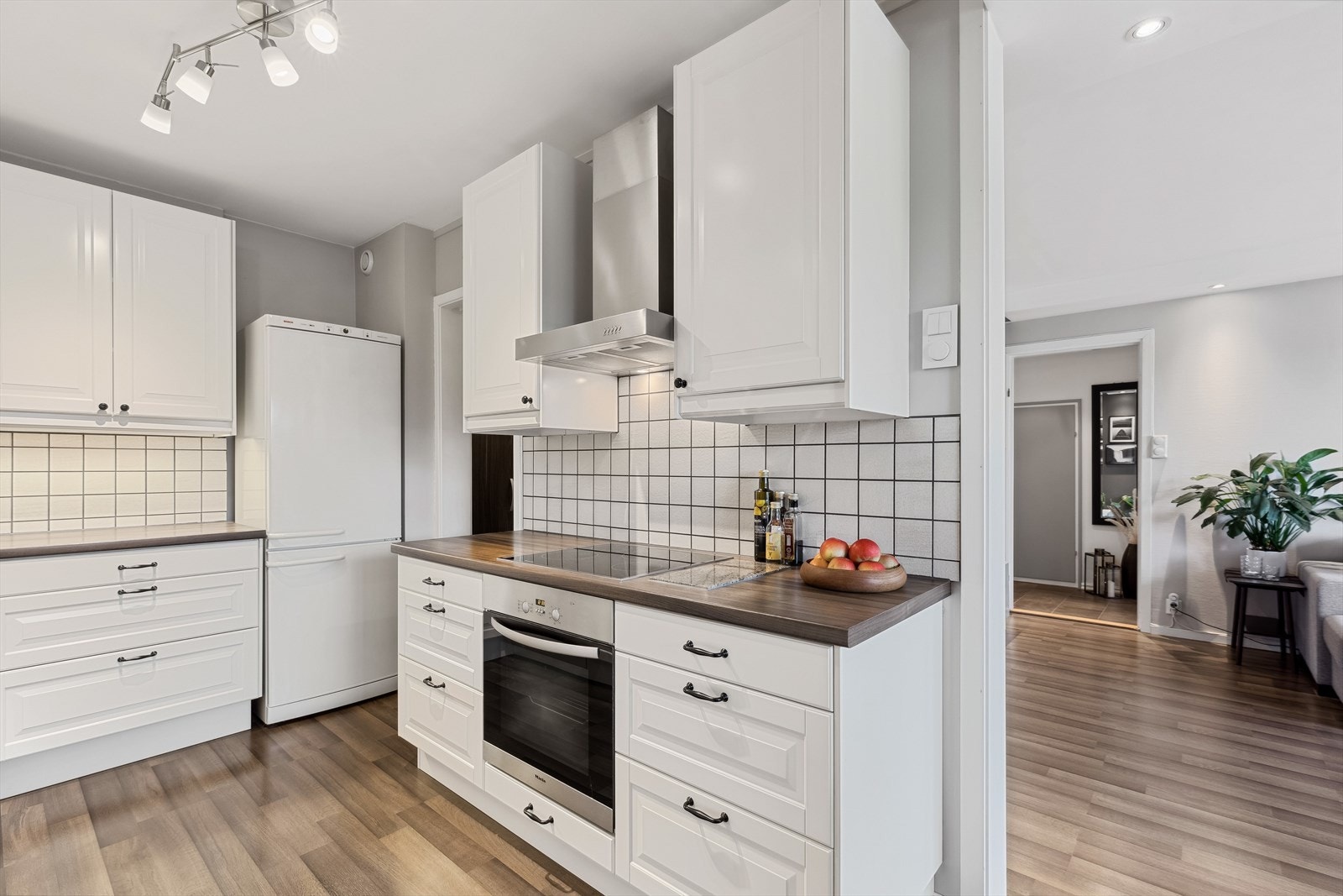 Kjøkkeninnredning med profilerte skapfronter og laminat benkeplate. Stekeovn og platetopp er integrerte i innredningen og det er avtrekkshette med kullfilter. Galleribilde