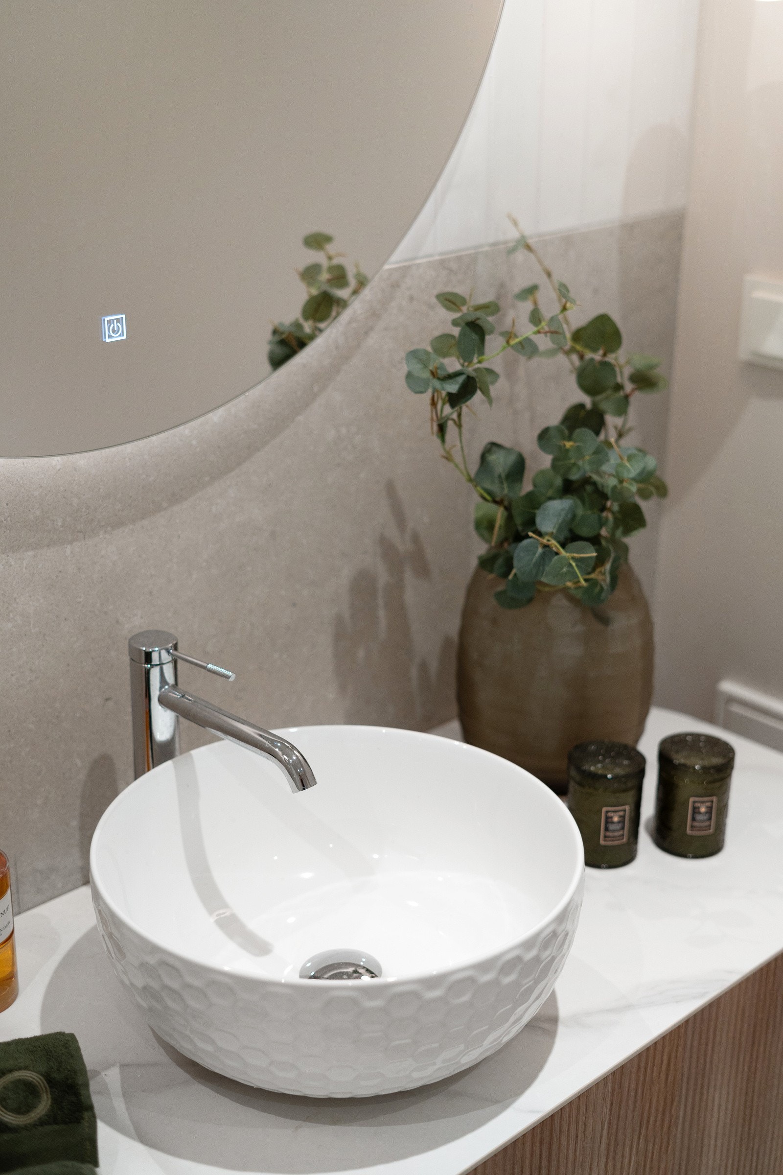 Delikat innredet med rundt ovenpåliggende servant i porselen, buede servant og speil med LED-belysning. Galleribilde