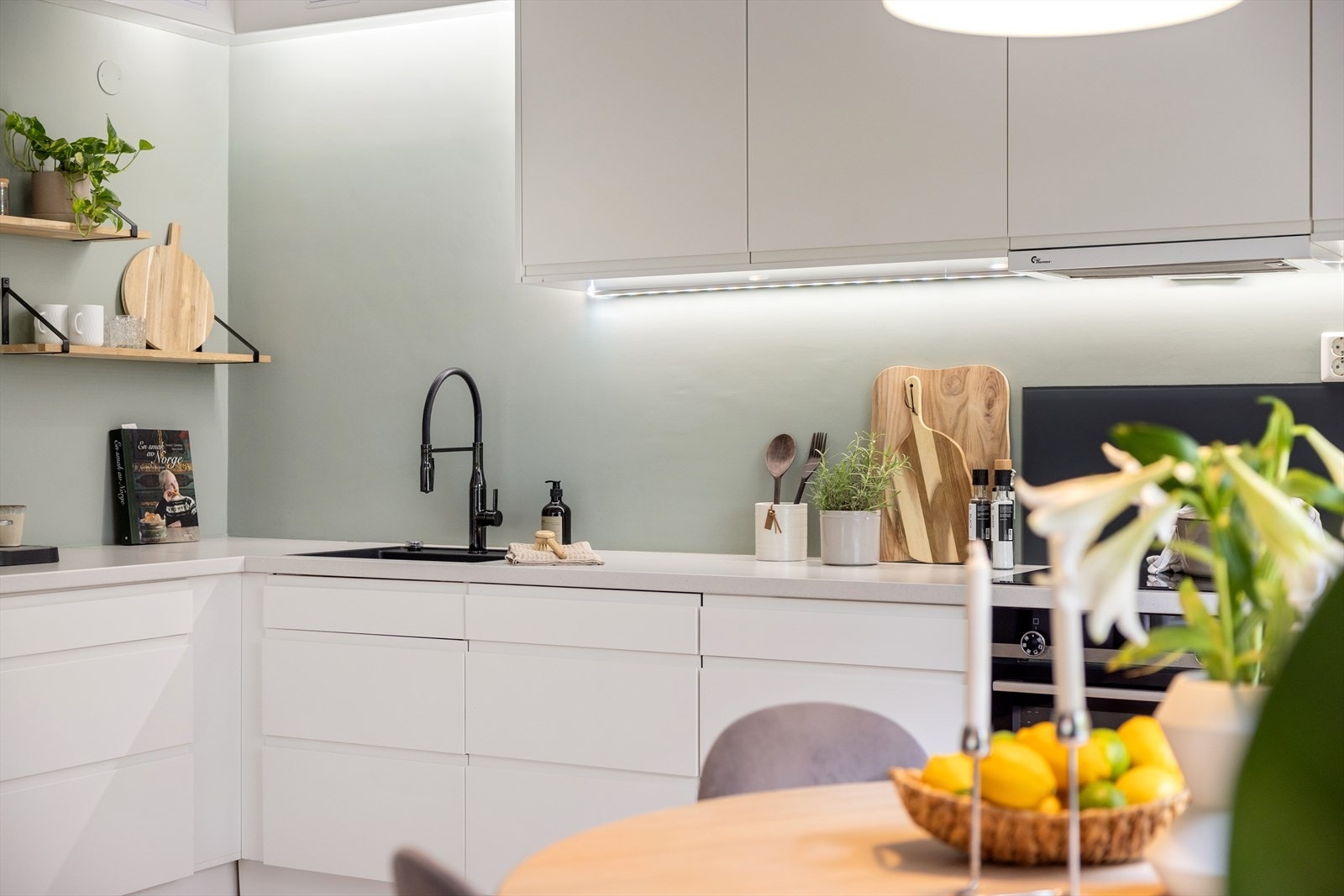 Tidsriktig innredning med glatte, hvite fronter og benkeplate i laminat Galleribilde