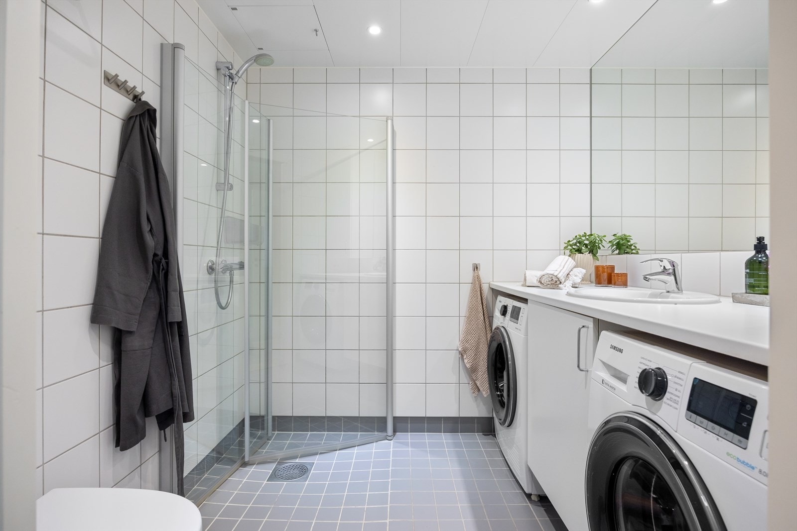 Stort, tidløst bad med flislagte overflater, gulvvarme og downlights i himling Galleribilde