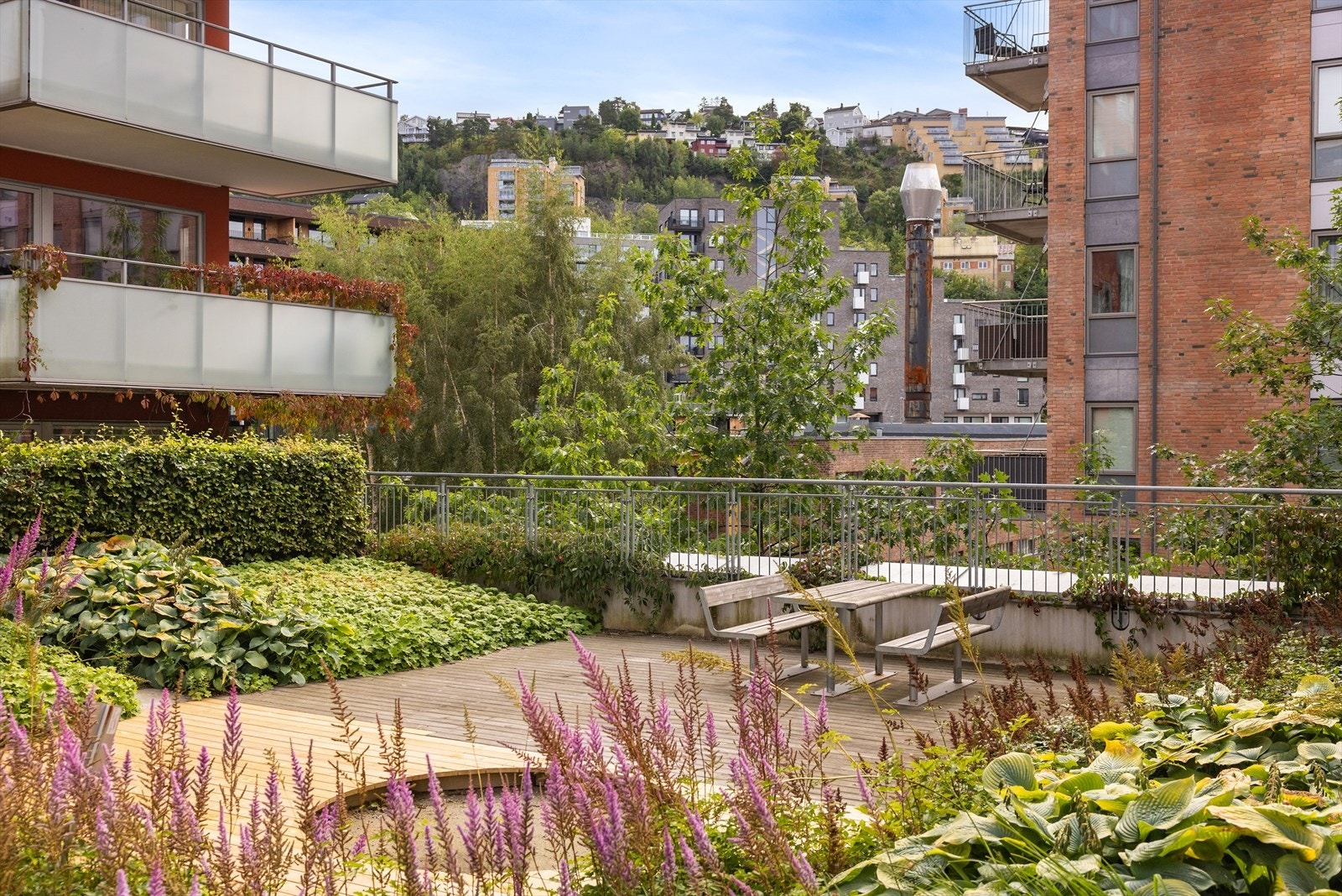 Fellesarealer med sittegrupper i frodige omgivelser Galleribilde