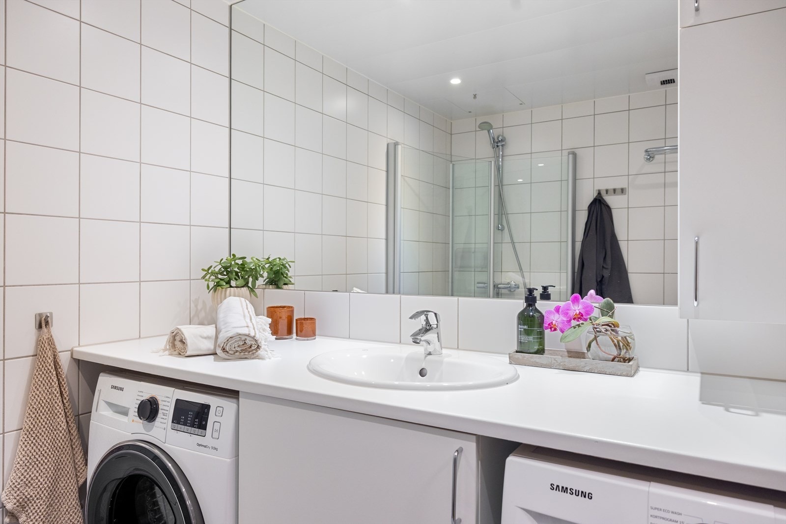 Innredning består av servantskap med nedfelt servant, underskap og 1-greps blandebatteri, dusjhjørne med glassdører, vegghengt toalett og opplegg for vaskemaskin Galleribilde