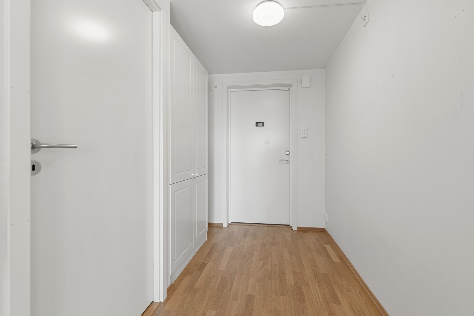 Lys og praktisk entré med garderobeskap og parkett på gulv. Galleribilde