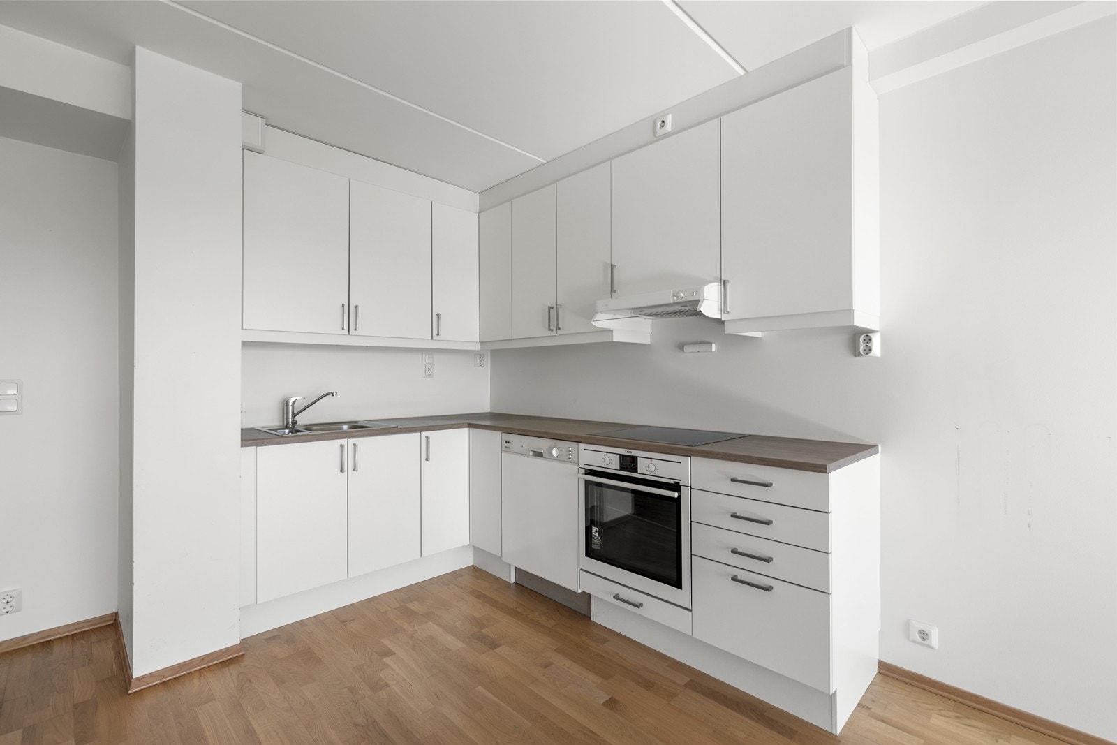 Kjøkkenet har innredning med glatte fronter og benkeplaten er av laminat. Det er integrerte hvitevarer som komfyr og platetopp, samt opplegg for oppvaskmaskin. Galleribilde