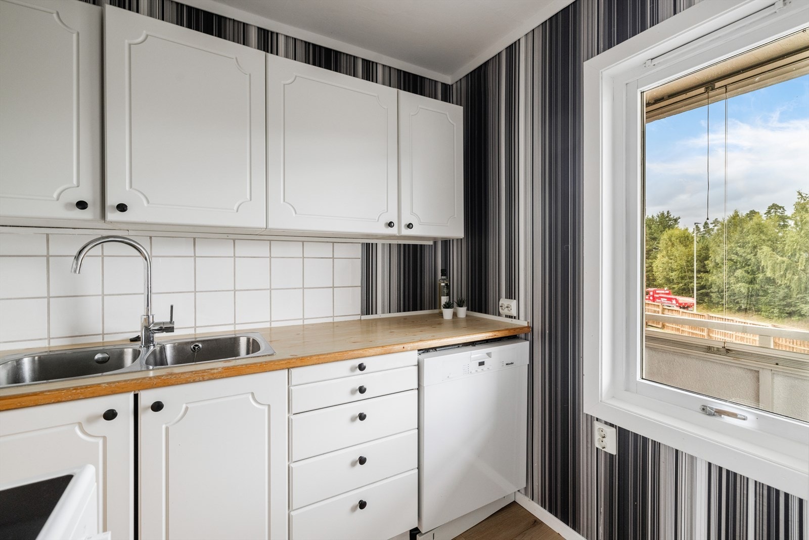 Over benkflater er det flis på vegg. Det er opplegg og plass for kjøl/fryseskap, oppvaskmaskin og komfyr. Galleribilde