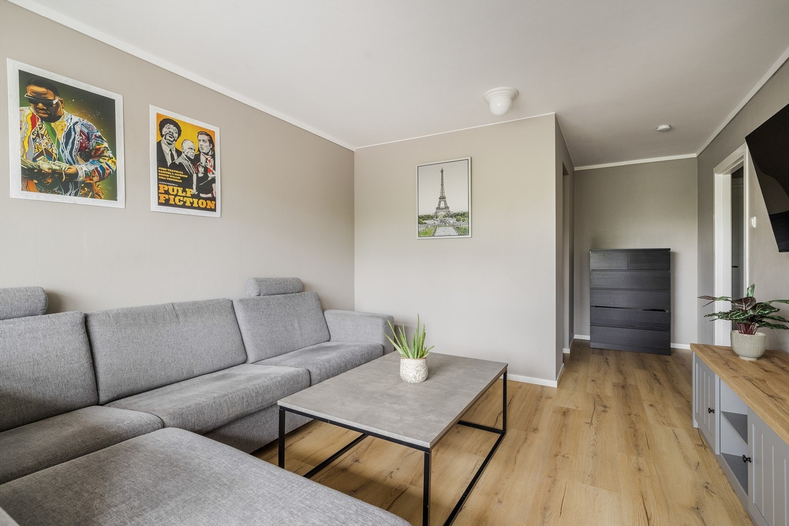 Lys og fin stue med plass til sofa og spisebord. Det er laminat på gulv, malte vegger og malt tak. Galleribilde