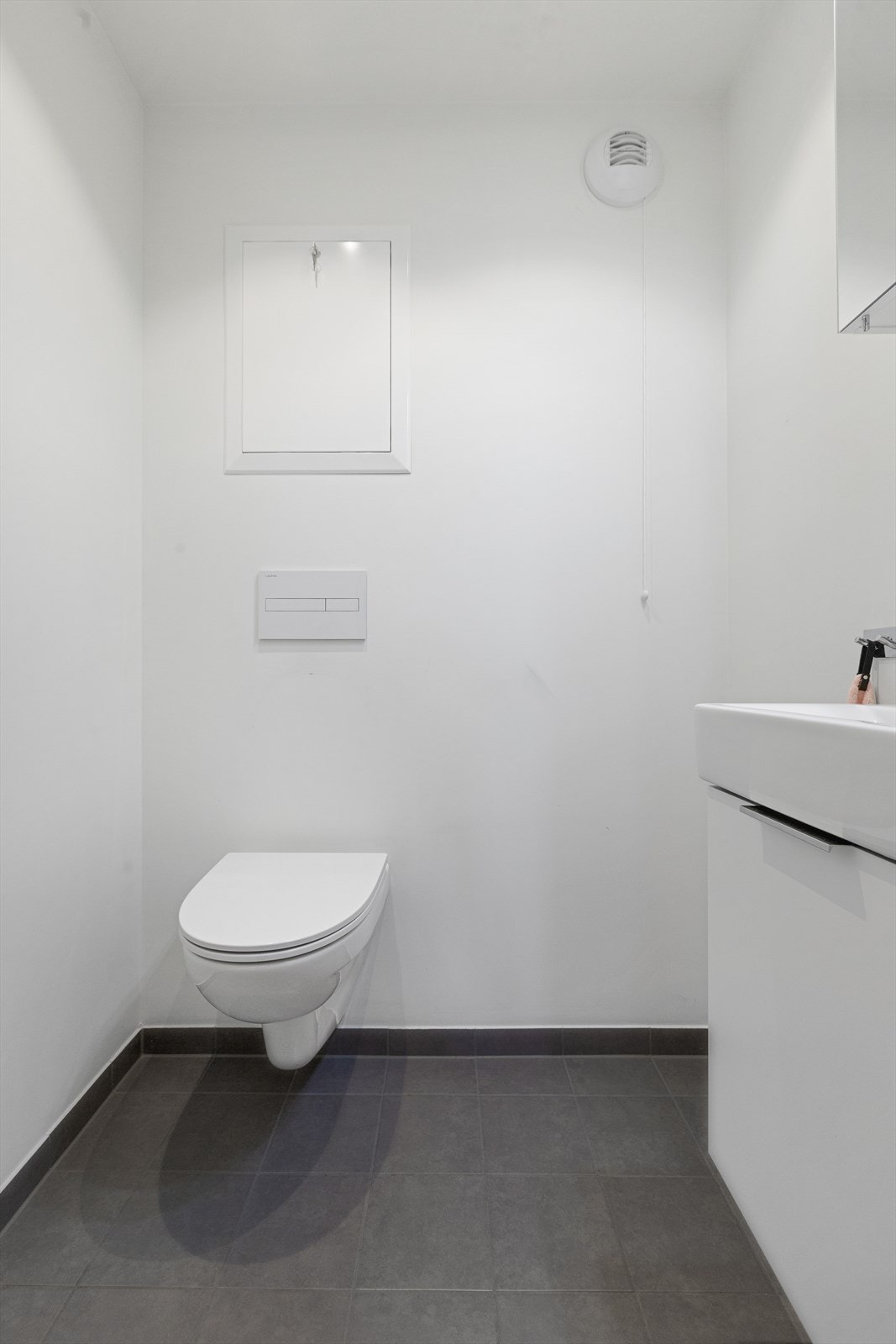 Nytt wc fra 2020 med fliser på gulv med varmekabler og flislagte vegger. Veggmontert wc. LED downlights med dimmer Galleribilde