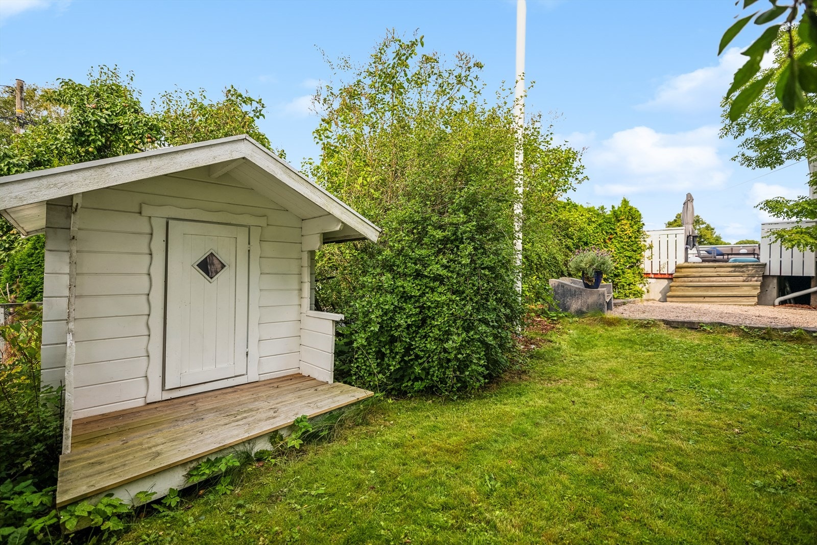 Flott hage med praktisk utehus og flaggstang. Galleribilde