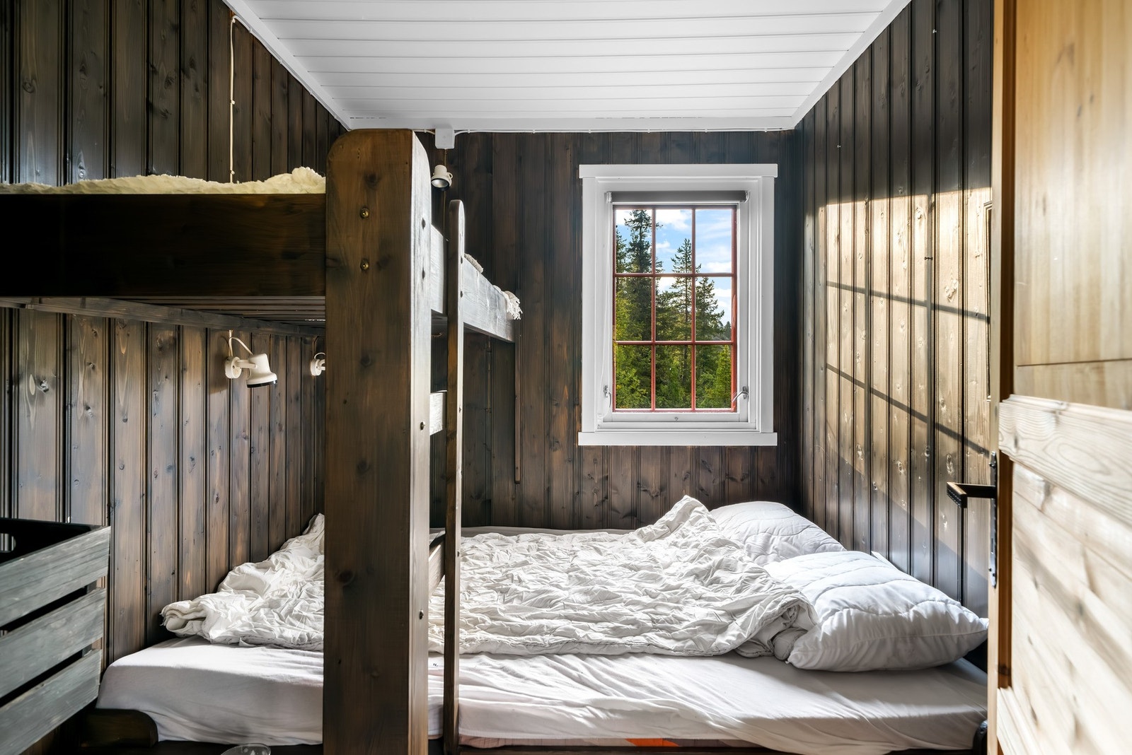 Det ene soverommet har en plassbygget dobbeltseng nede, med overkøye, og noe plass til oppbevaring Galleribilde