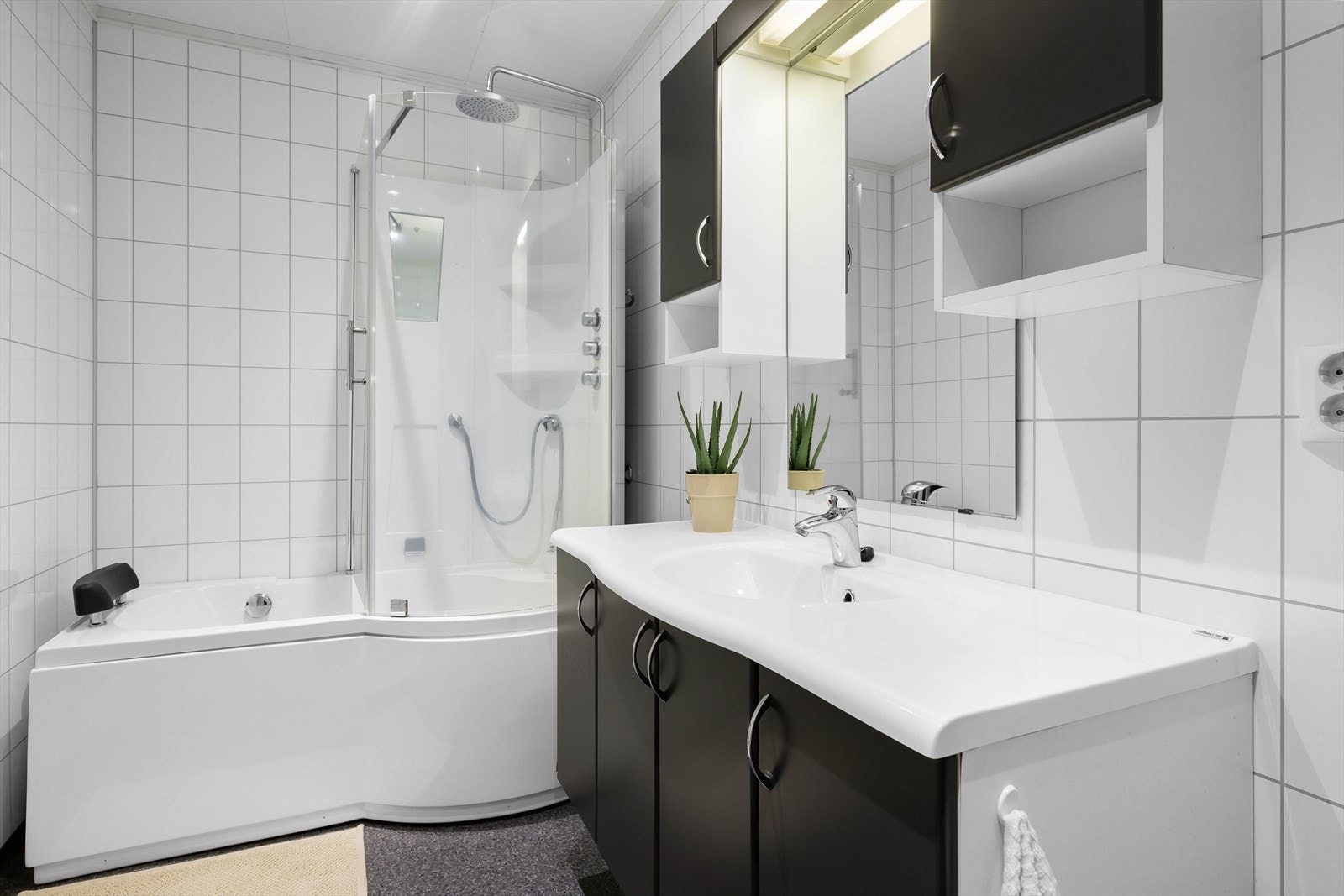 Badet er innredet med toalett, badekar m/ dusjvegg, servantskap, overskap, speil og belysning Galleribilde