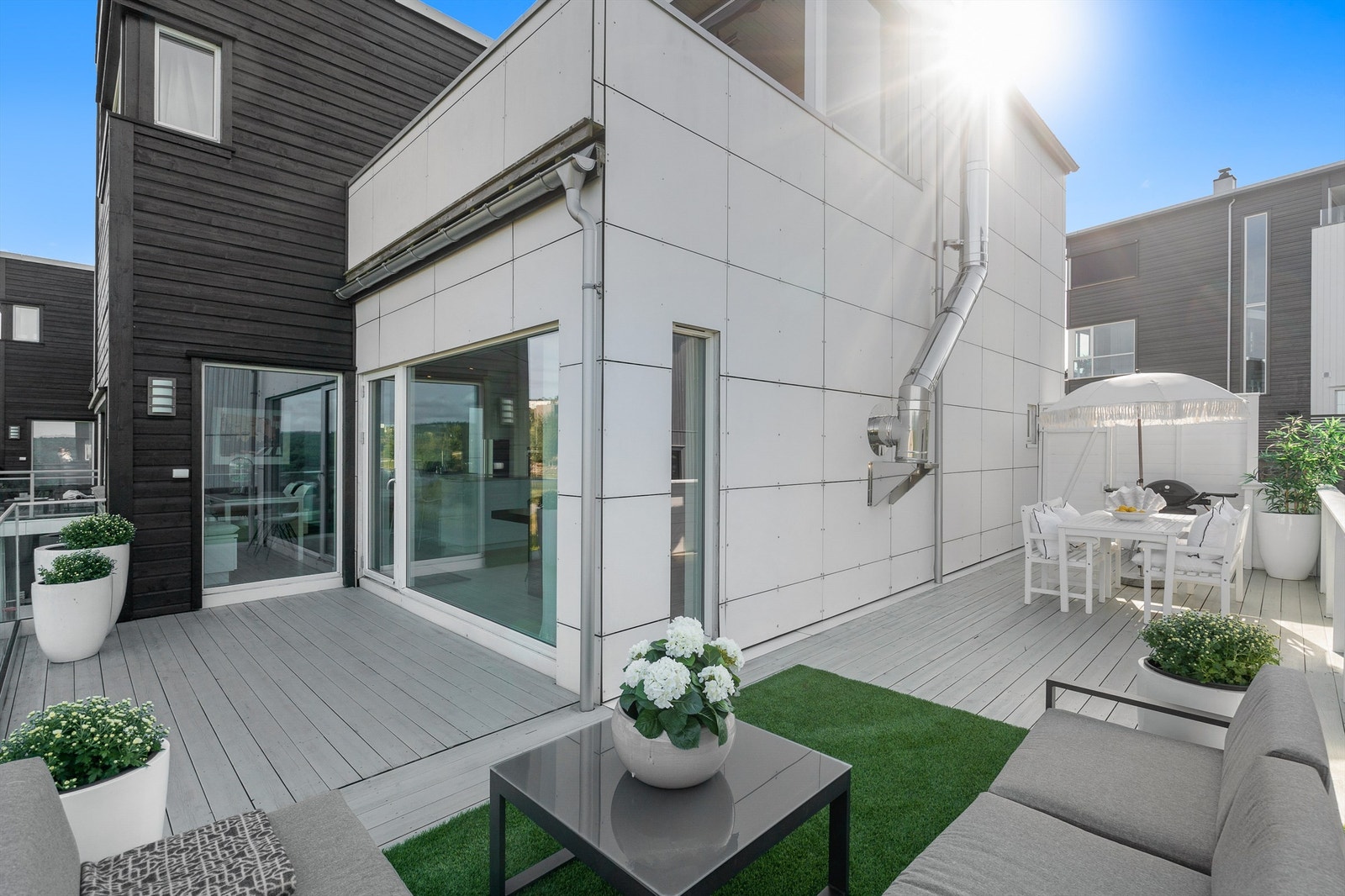 Fra stuen/kjøkkenet i hovedetasjen er det utgang til solrik og skjermet terrasse med rikelig plass til både sofa- og spisegruppe. Galleribilde