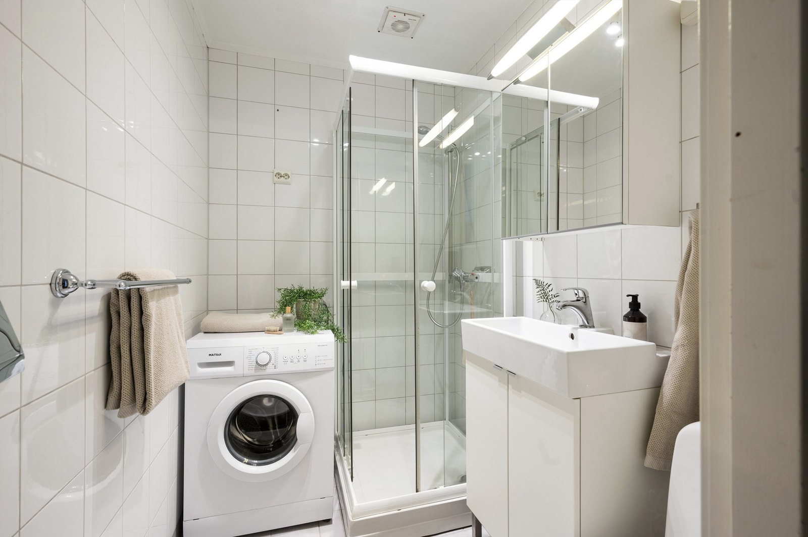 Lyst og flislagt baderom fra 2004 med gulvvarme. Badet er innredet med gulvstående wc fra 2012, heldekkende servant fra 2011 med underskap i glatte fronter, vegghengt speilskap og dusjkabinett fra 2011. Galleribilde