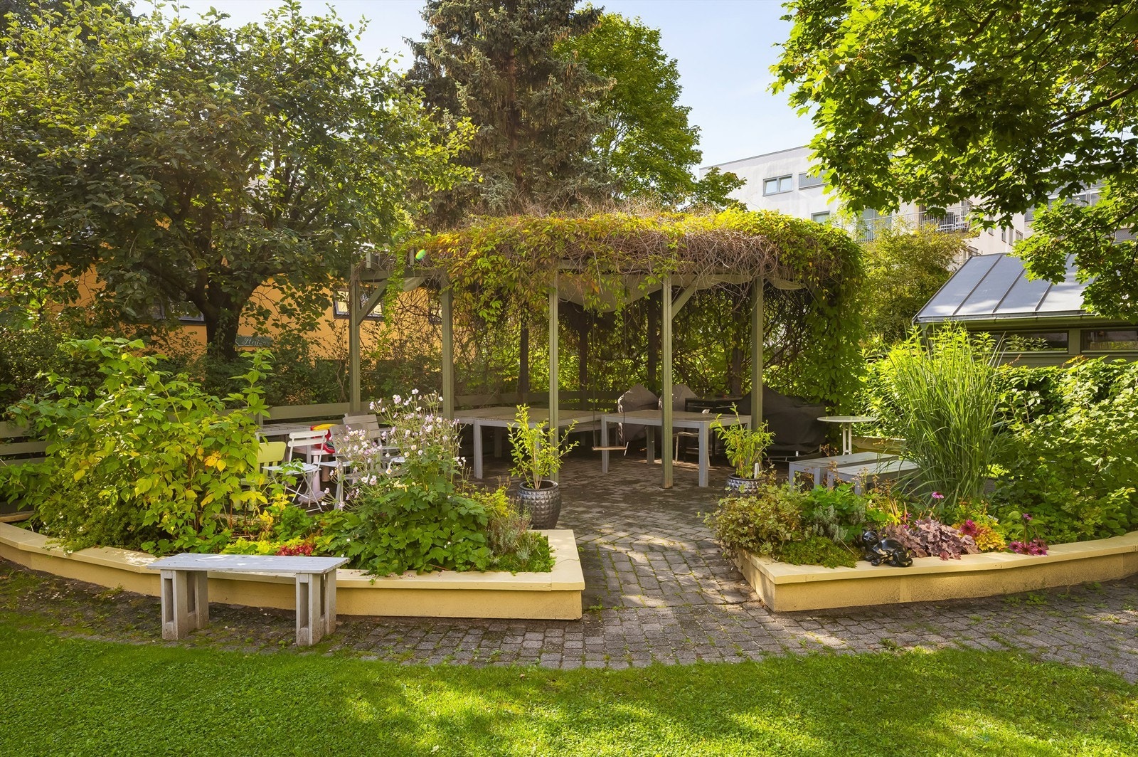 Flott, felles bakgård i borettslaget og i kvartalet, med store plenarealer, pergola, sittegrupper og felles grillplass. Galleribilde
