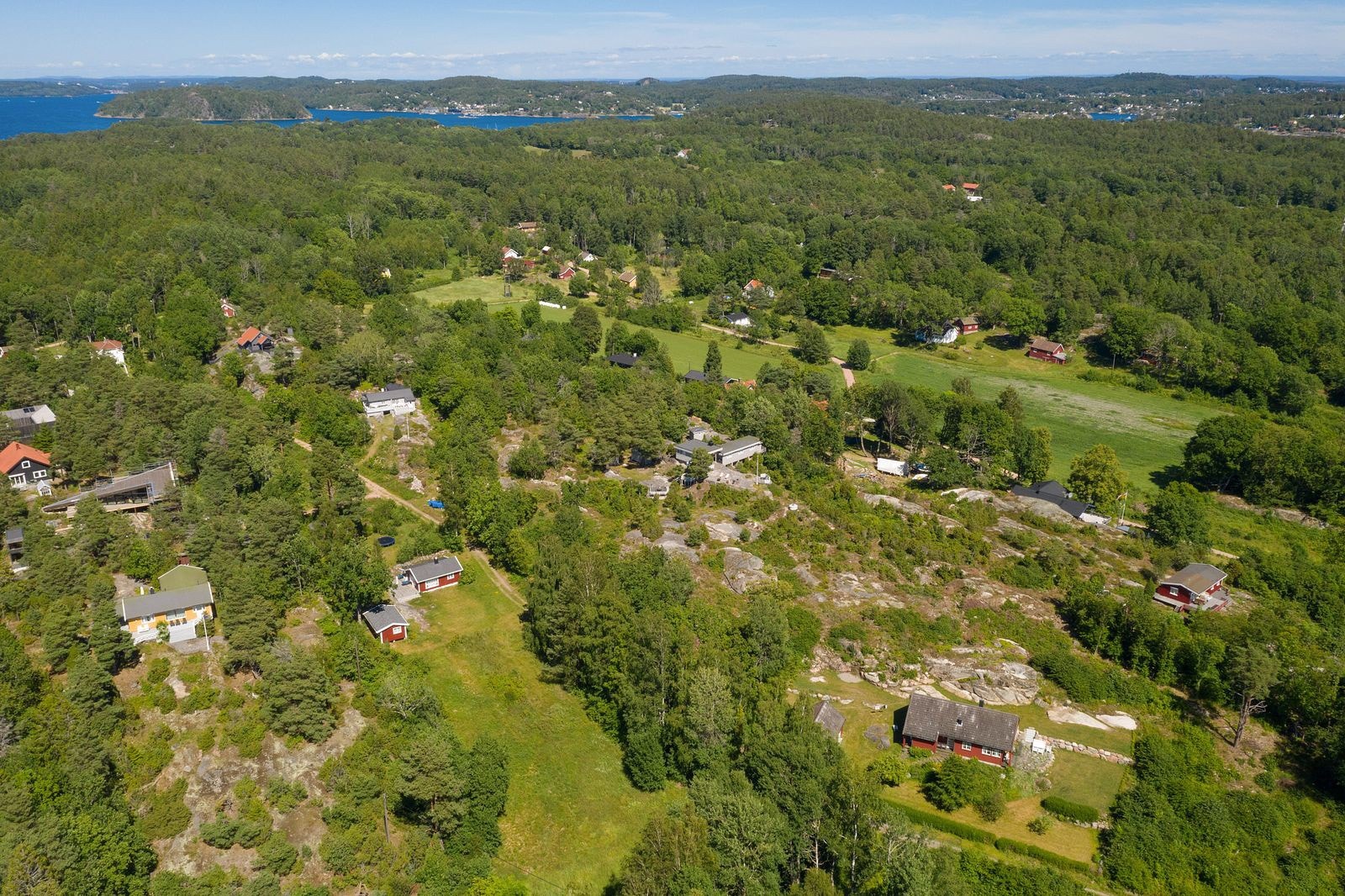 Tomten ligger til venstre for den røde hytten Galleribilde