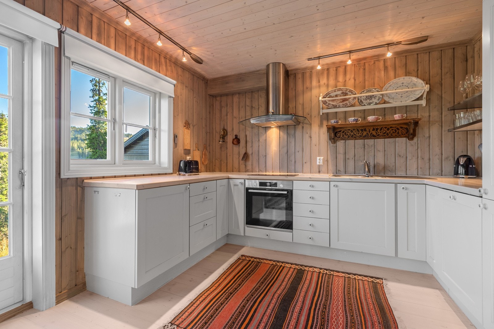 Kjøkkenet ligger innenfor spisestuen og har grå heltre innredning bestående av underskap. Galleribilde