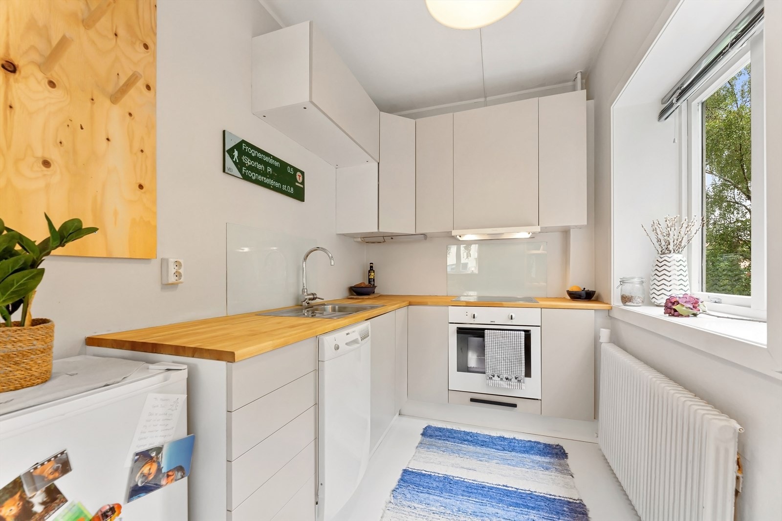 Kjøkkenet er stilrent og funksjonelt med lyse skapfronter og en benkeplate i tre. Galleribilde