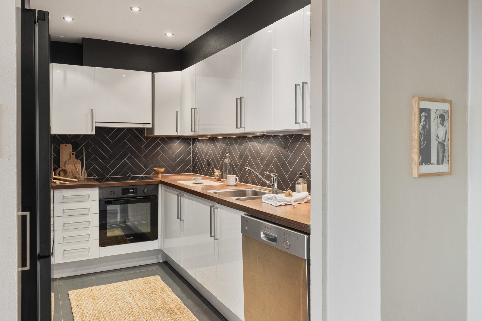 Kjøkkenet fremstår moderne med lekkert design, innredningen består av- slette høyglans fronter, slitesterk laminat benkeplate med underlimt vask av stål og kitchenboard over benkeplaten. Galleribilde