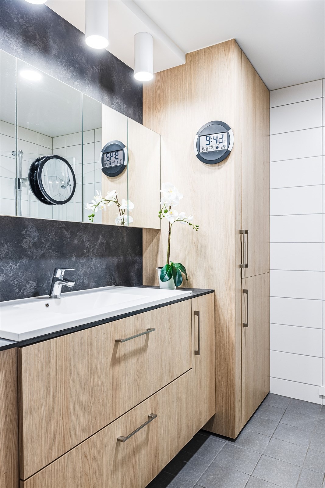 Påkostet baderomsinnredning med god oppbevaringsplass og stor nedfelt servant, flere vegghengte speilskap og takhengt belysning over. Galleribilde