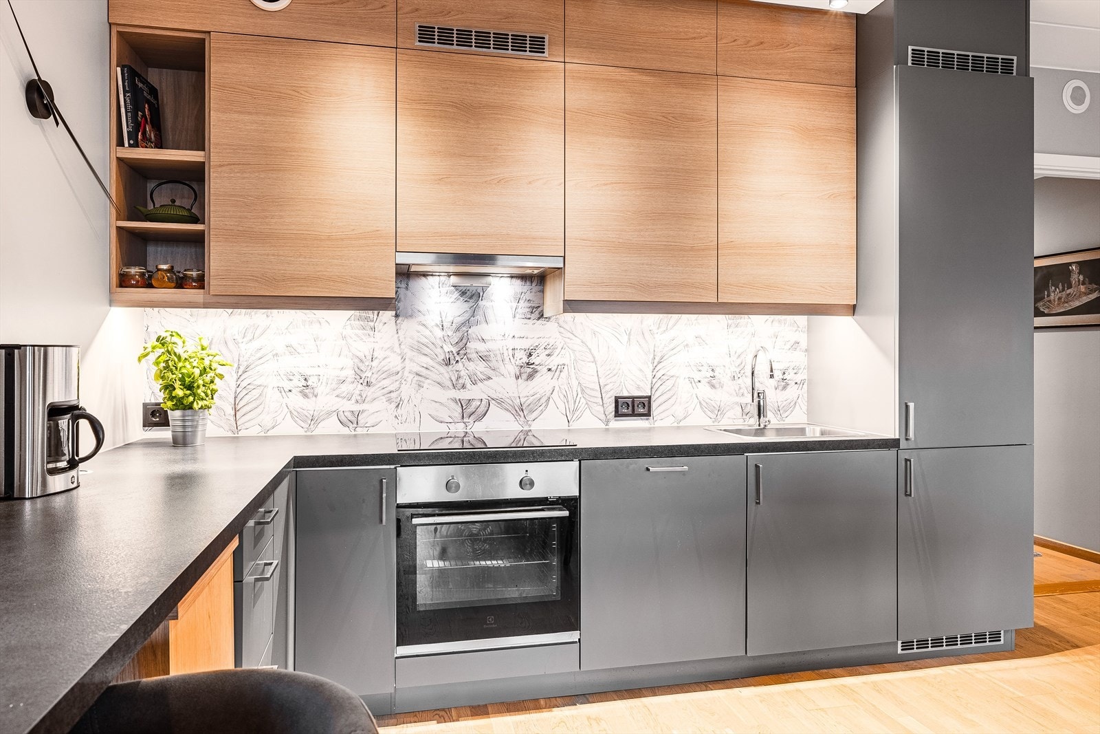 Innredningen har glatte fronter og laminerte benkeplate med planlimt oppvaskkum. Praktisk med belysning under de takhøye overskapene. Galleribilde