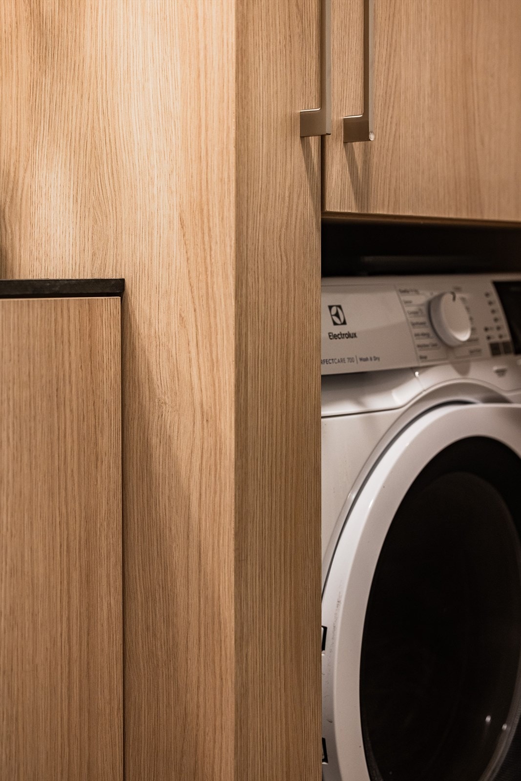 Meget flott innredning med plass og opplegg for vaskemaskin inni skap. Galleribilde