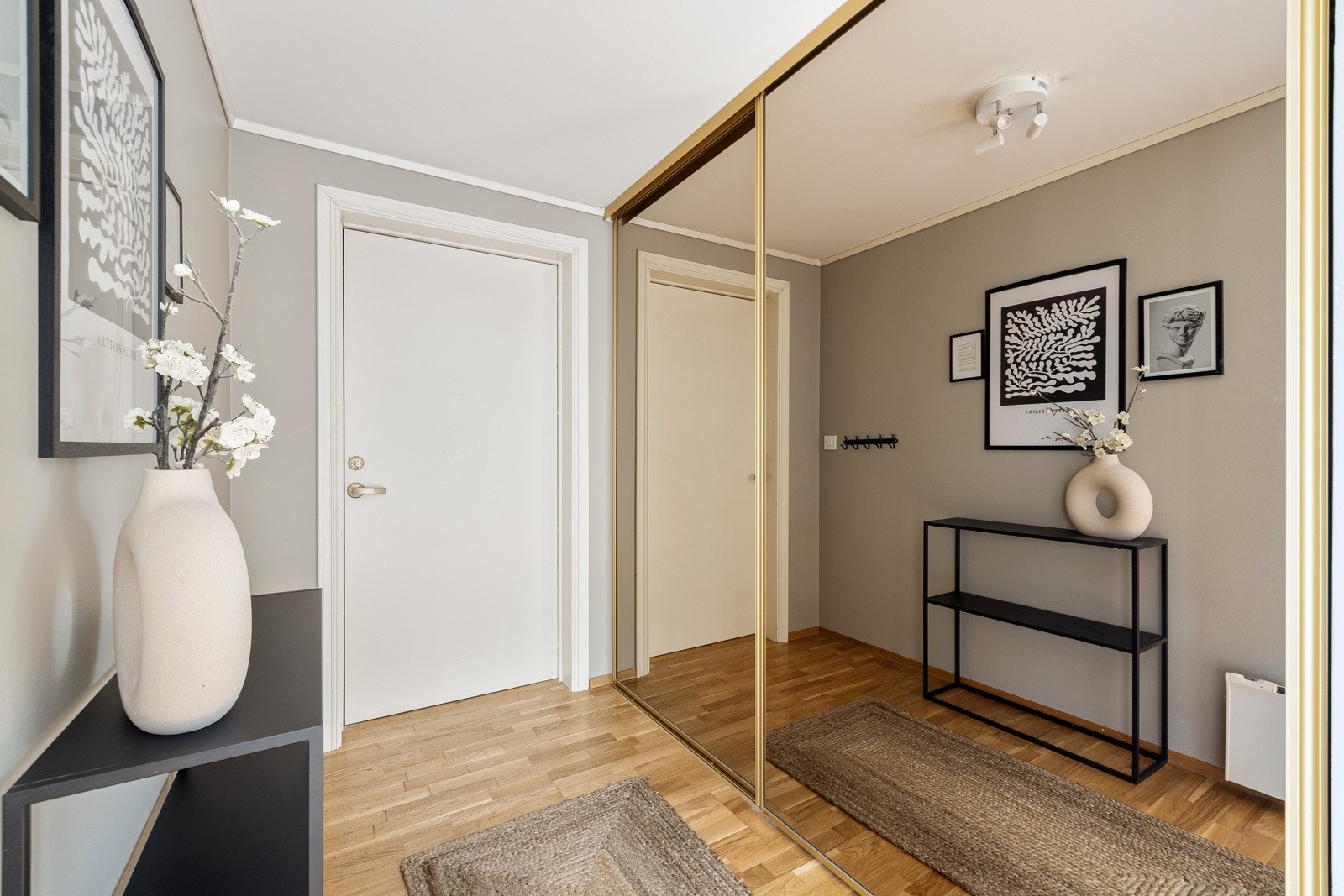 Velkommen inn i entreen som gir en varm velkomst med lyse overflater og gjennomgående parkett på gulvet. Galleribilde