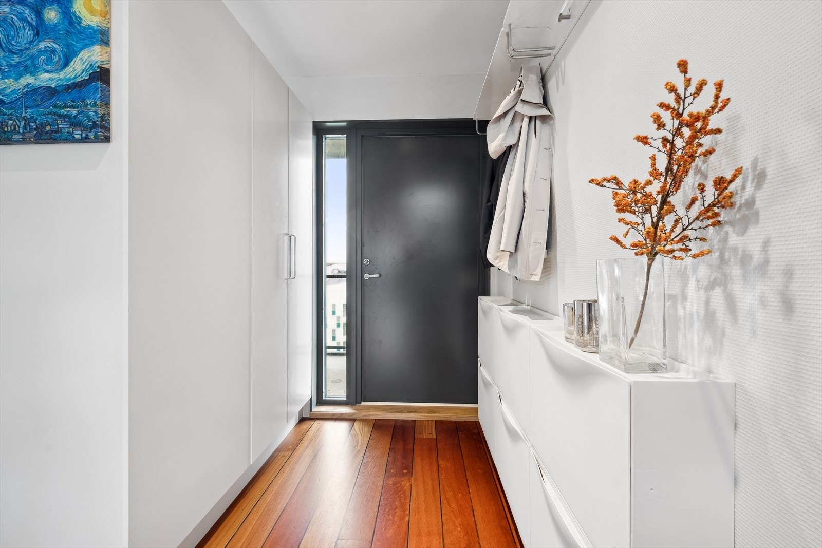 Inngangspartiet er åpent og lyst, og det er gjennomgående parkett i hele leiligheten. Her er det plass til sko og yttertøy. Videre ledes du inn til stuen og kjøkkenet, som har en åpen løsning. Galleribilde