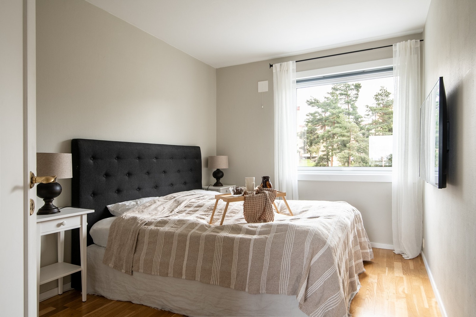 Soverommet er lyst og romslig, med god plass til en dobbeltseng, nattbord på hver side og et garderobeskap for oppbevaring. Galleribilde